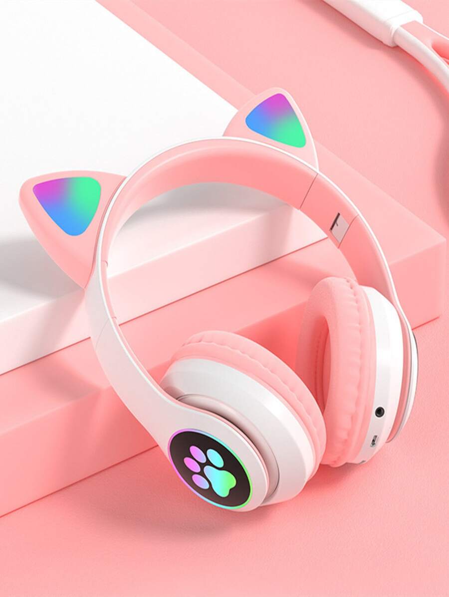 Pink headphones with cat ear design and paw print on a pink background